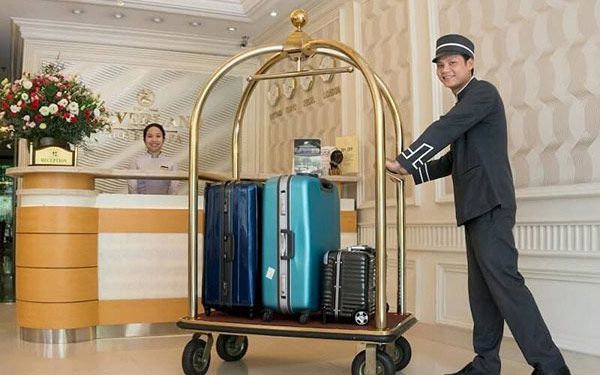 Bellman đẩy hành lý hướng dẫn khách nhận phòng